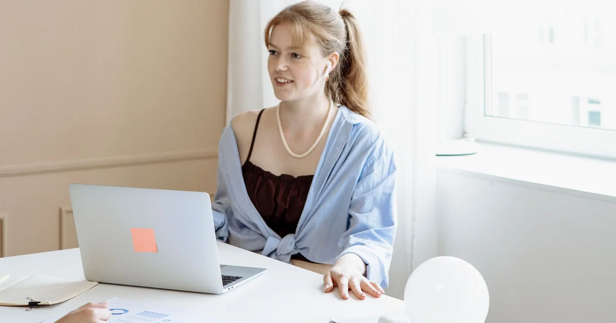 A professional working on a laptop in a naturally lit office.