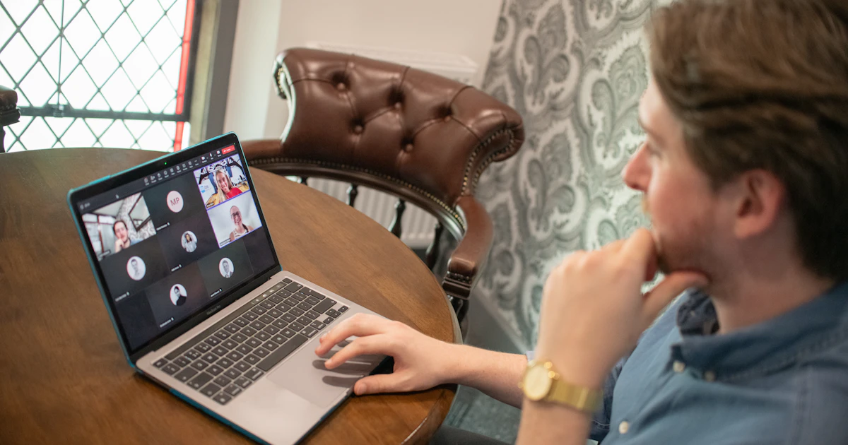 A professional joining a video conference on a laptop.